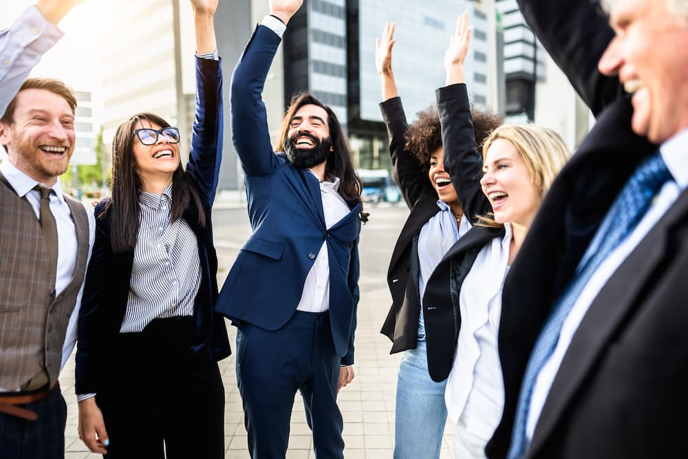 Happy employees with sales and marketing jobs celebrating.